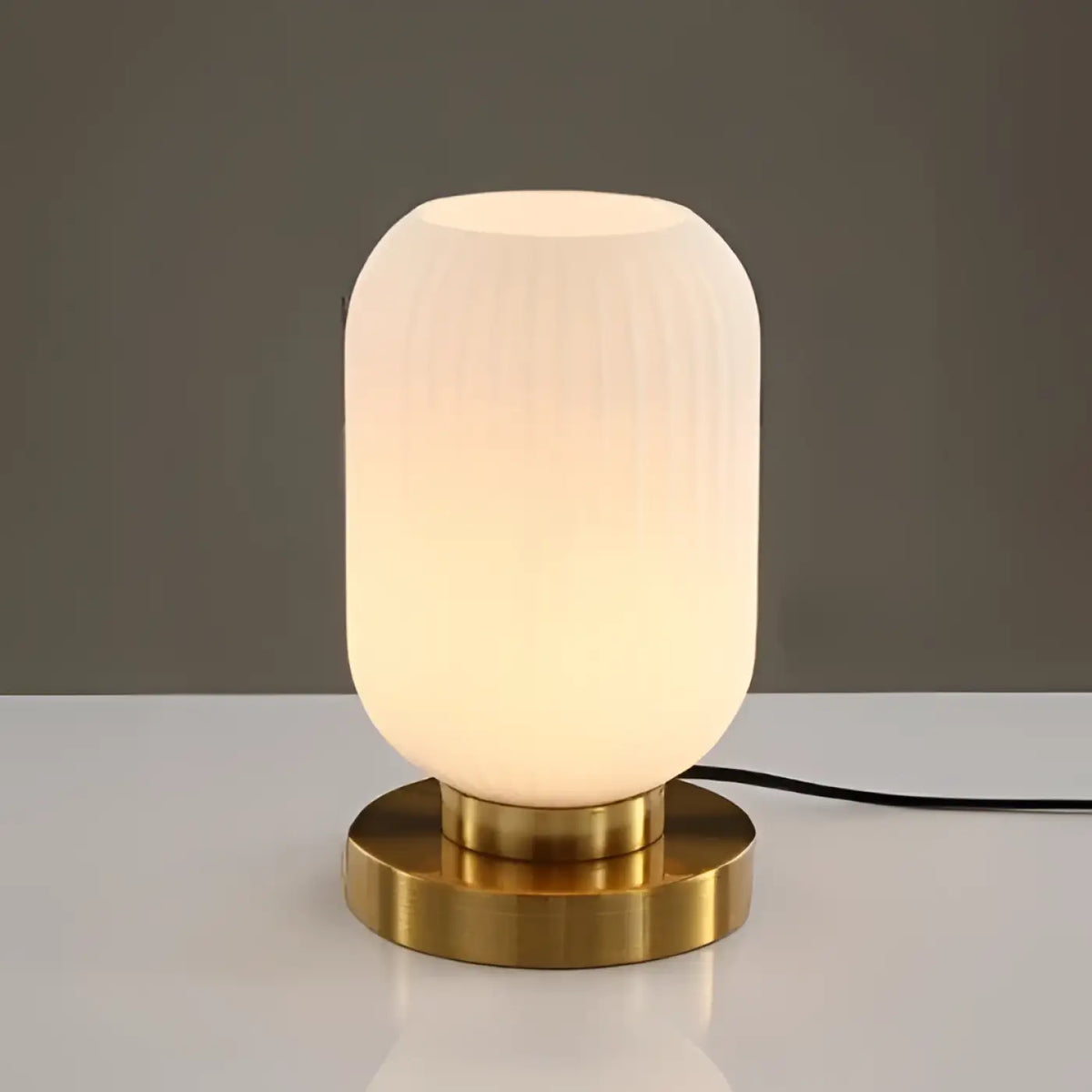 Lampe de table véty avec abat-jour en verre blanc dépoli cannelé et socle en laiton poli piles sont-elles incluses